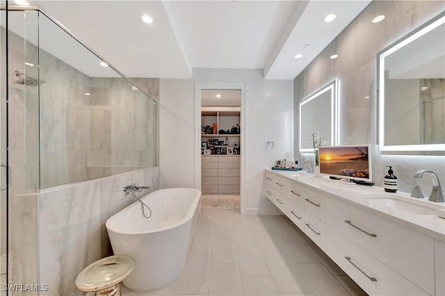 bathroom with vanity, tile patterned floors, tile walls, and separate shower and tub