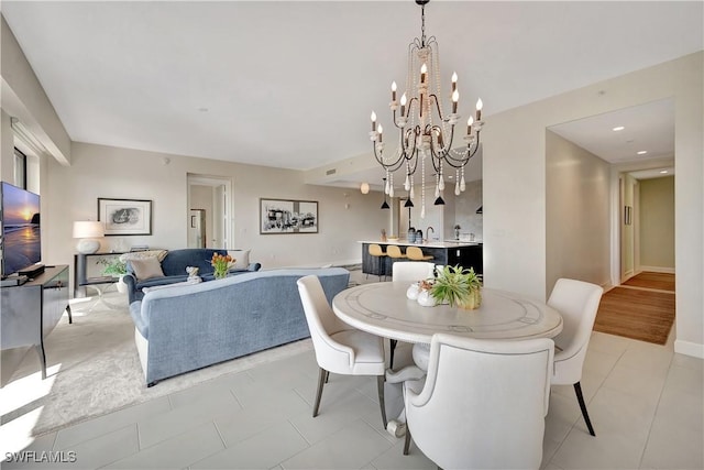 dining room with light tile patterned flooring and a notable chandelier