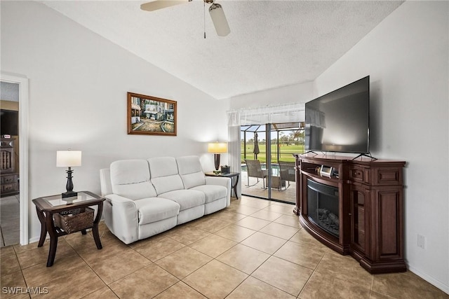 tiled living room with ceiling fan, lofted ceiling, and a textured ceiling