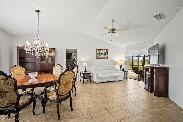 dining room with lofted ceiling, ceiling fan with notable chandelier, a textured ceiling, and light tile patterned flooring