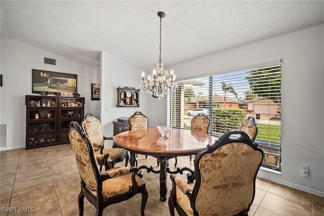 dining room with lofted ceiling, light tile patterned floors, a textured ceiling, and an inviting chandelier