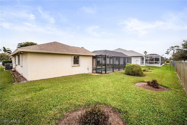 view of yard with a pool, glass enclosure, and central air condition unit