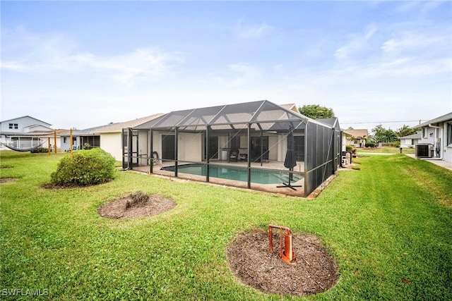 rear view of property featuring a lanai, a lawn, and central air condition unit