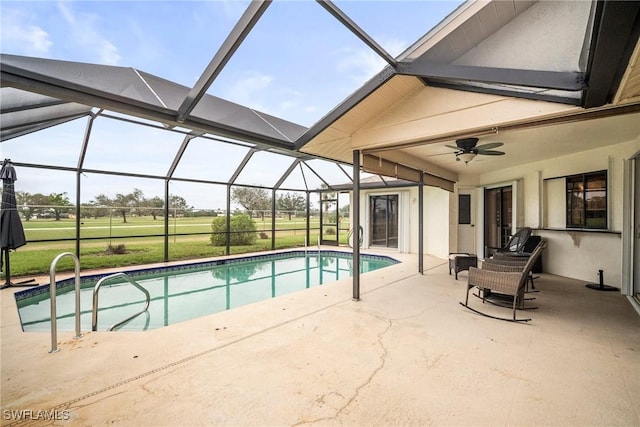 view of swimming pool with a patio, ceiling fan, and glass enclosure