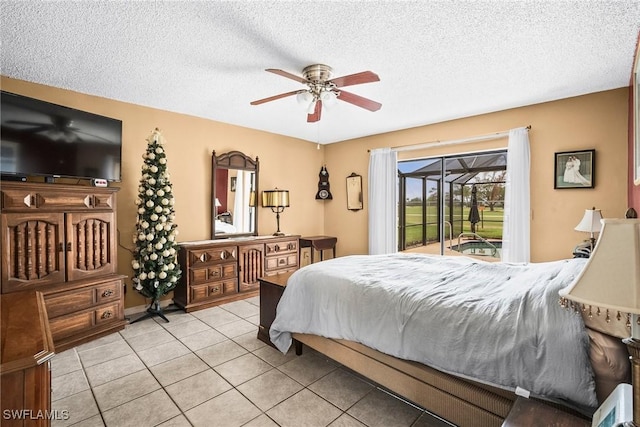 bedroom with ceiling fan, light tile patterned floors, a textured ceiling, and access to outside