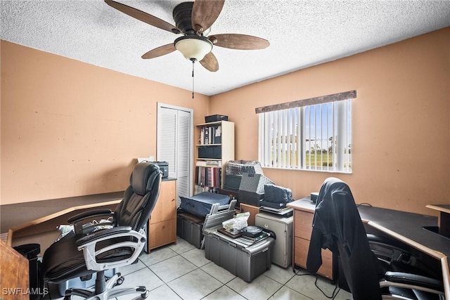 tiled office space featuring ceiling fan and a textured ceiling