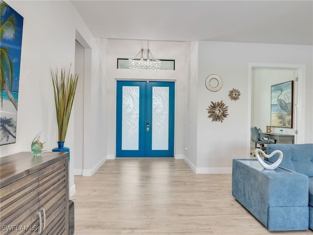 foyer entrance with light hardwood / wood-style flooring and french doors