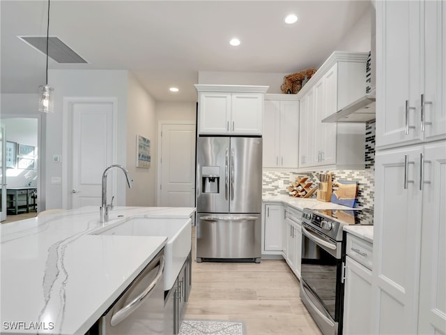 kitchen featuring stainless steel appliances, white cabinetry, pendant lighting, and backsplash