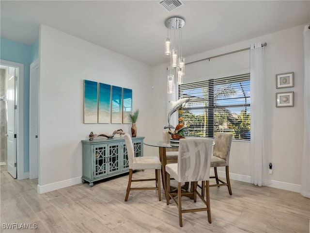 dining room with a chandelier and light wood-type flooring