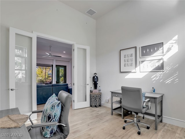 home office featuring french doors and light wood-type flooring