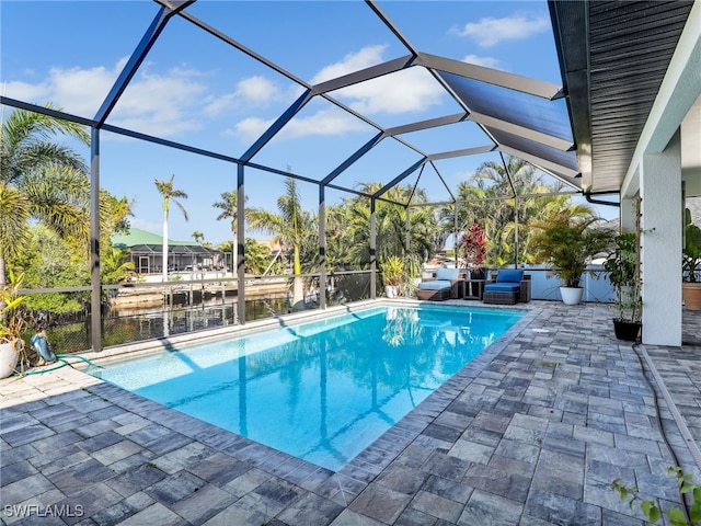 view of pool featuring a water view, a lanai, and a patio area