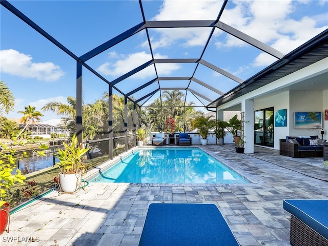 view of pool with an outdoor living space, a patio, a water view, and glass enclosure