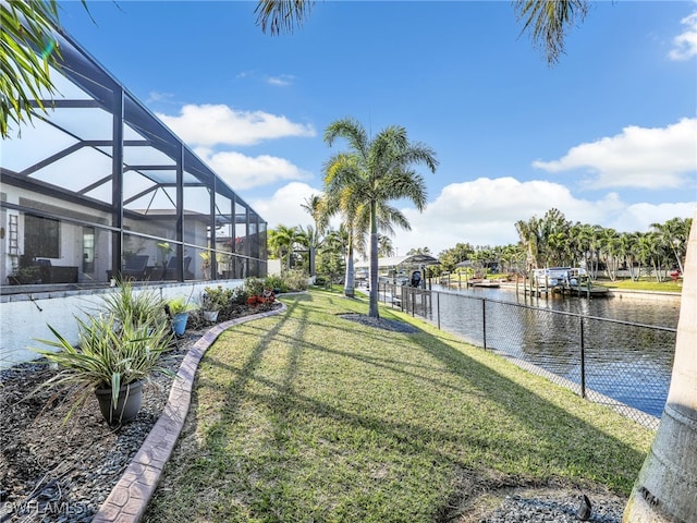 view of yard with a water view and a lanai