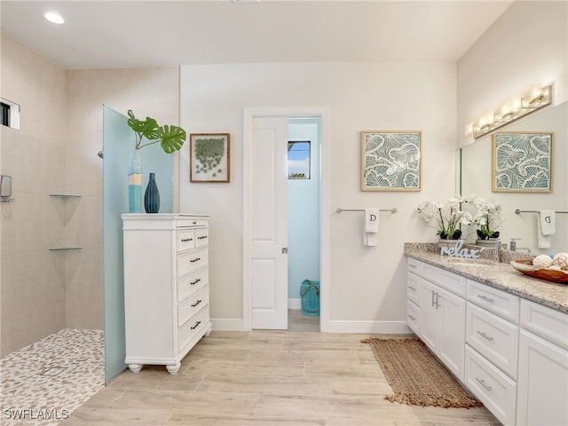 bathroom featuring vanity, tiled shower, and hardwood / wood-style floors