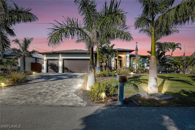 view of front of house featuring a garage and a yard