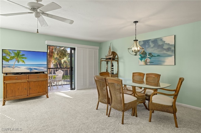 carpeted dining area featuring ceiling fan with notable chandelier