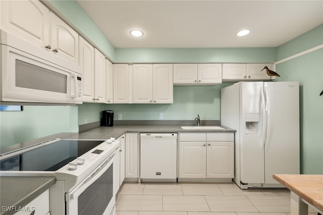 kitchen featuring sink, white cabinets, and white appliances