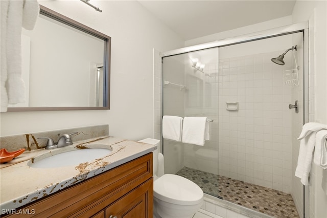 bathroom with walk in shower, vanity, and toilet