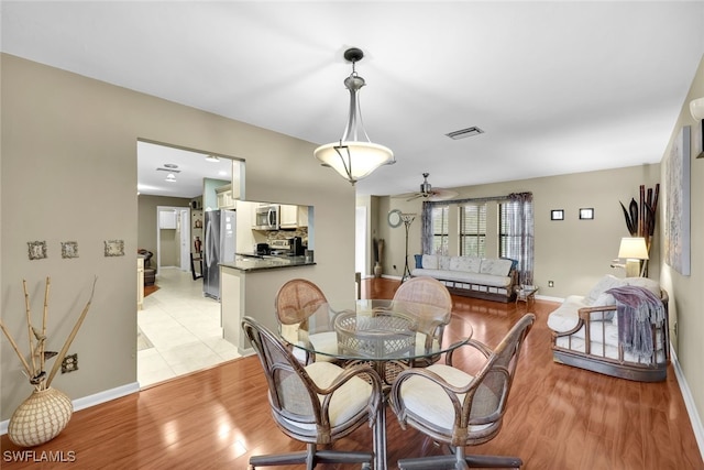 dining room with ceiling fan and light hardwood / wood-style floors