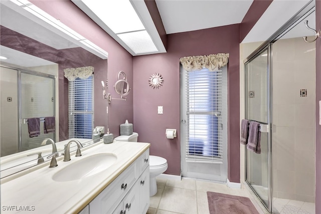 bathroom featuring vanity, toilet, an enclosed shower, and tile patterned flooring