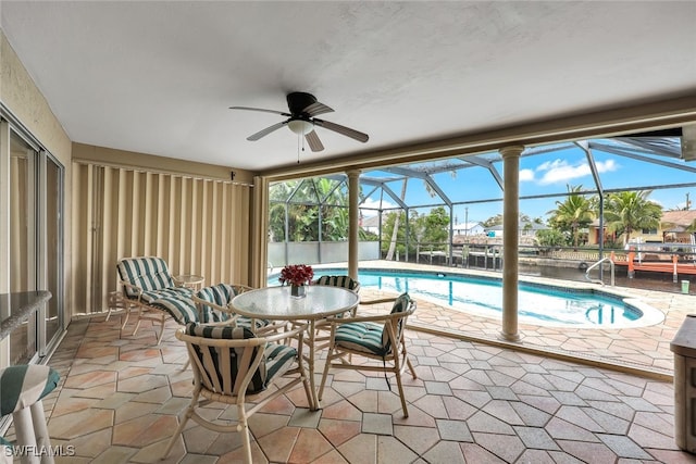 sunroom featuring ceiling fan and a pool