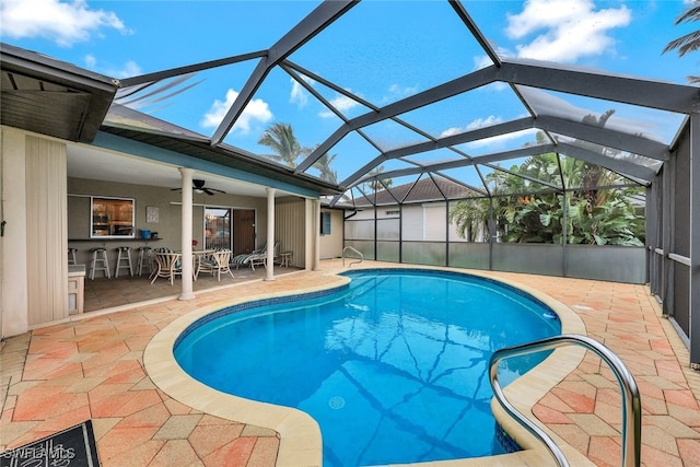 view of swimming pool with a lanai, a patio area, an outdoor bar, and ceiling fan