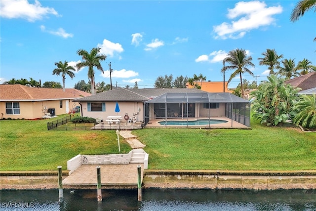 back of house featuring a water view, a lanai, and a yard