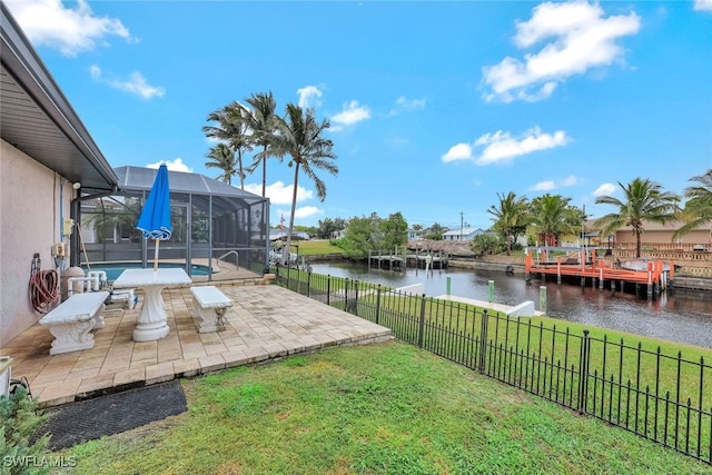 view of yard featuring a water view, glass enclosure, and a patio area