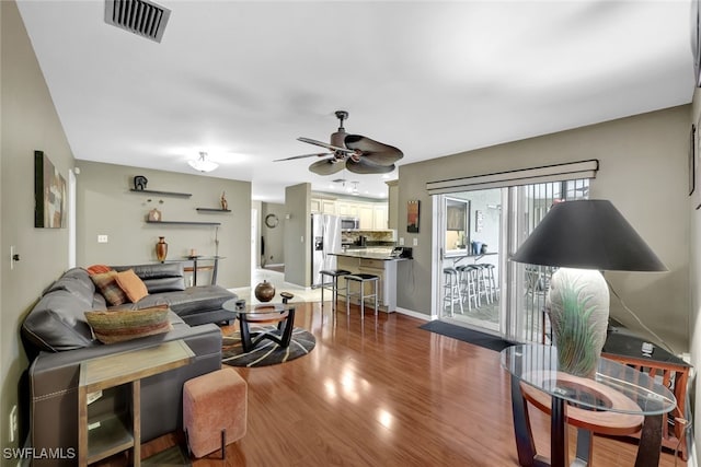 living room with hardwood / wood-style floors and ceiling fan