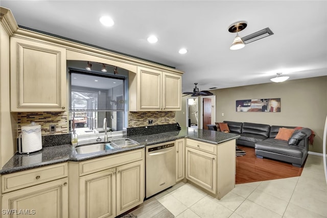 kitchen featuring sink, light tile patterned floors, dishwasher, kitchen peninsula, and backsplash