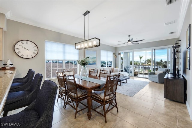 dining room featuring ceiling fan, ornamental molding, and light tile patterned floors