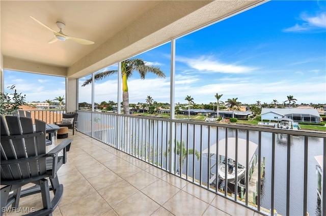 sunroom / solarium featuring a water view and ceiling fan