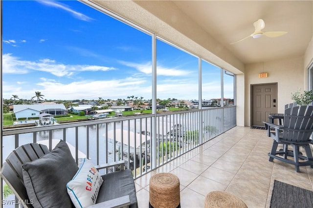 balcony featuring ceiling fan and a water view