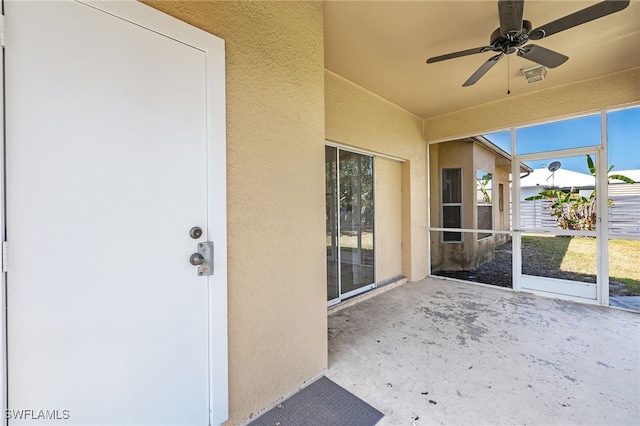 unfurnished sunroom with ceiling fan