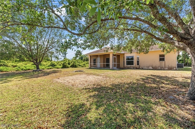 back of house featuring a yard, central AC, and a sunroom