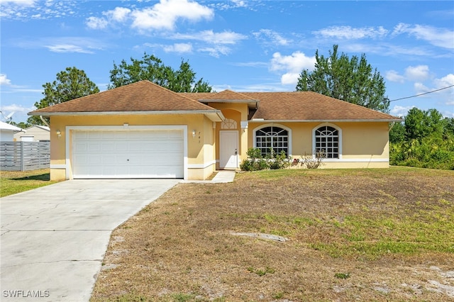 single story home featuring a garage and a front lawn