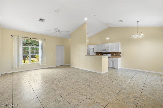 unfurnished living room with ceiling fan with notable chandelier, light tile patterned floors, and high vaulted ceiling