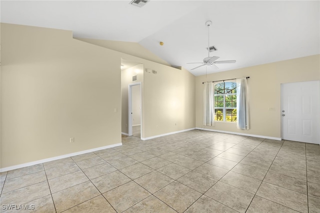 spare room featuring vaulted ceiling, light tile patterned floors, and ceiling fan