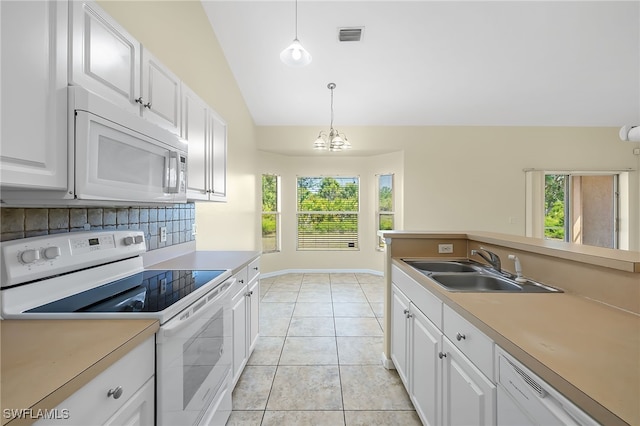 kitchen featuring white appliances, white cabinets, light tile patterned flooring, decorative light fixtures, and vaulted ceiling