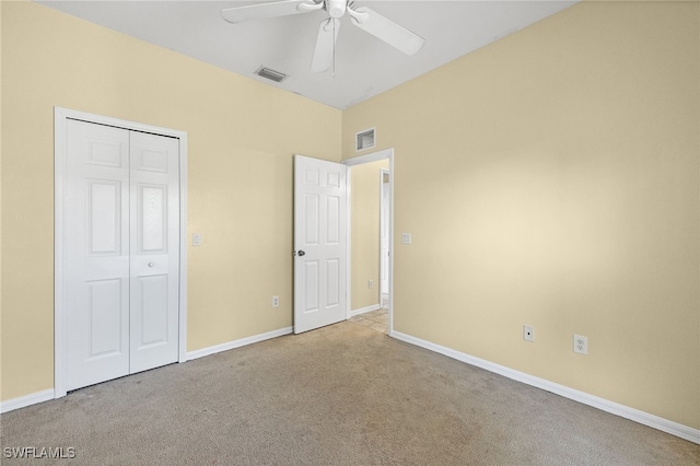 unfurnished bedroom with ceiling fan, light colored carpet, and a closet