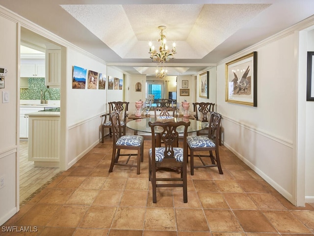 dining room featuring baseboards, a tray ceiling, a chandelier, and a textured ceiling