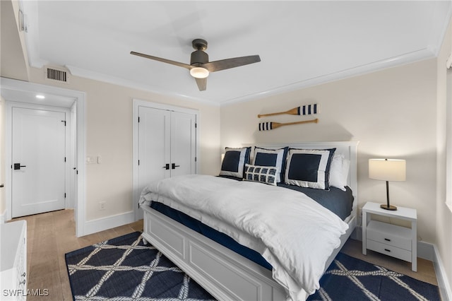 bedroom featuring ornamental molding, ceiling fan, and a closet