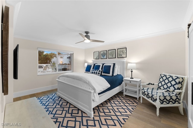 bedroom with wood-type flooring, ornamental molding, and ceiling fan