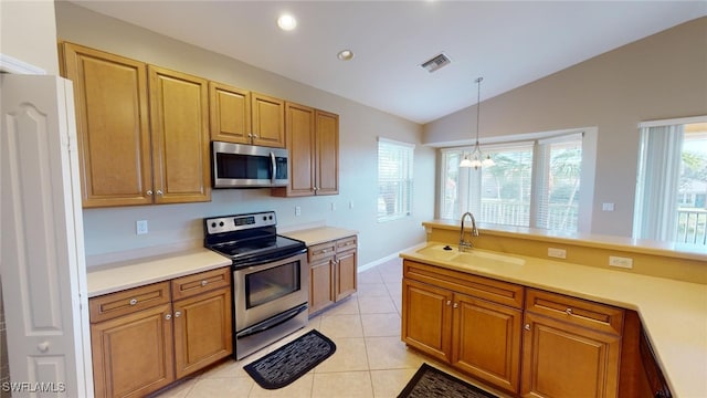 kitchen featuring lofted ceiling, sink, pendant lighting, light tile patterned floors, and stainless steel appliances