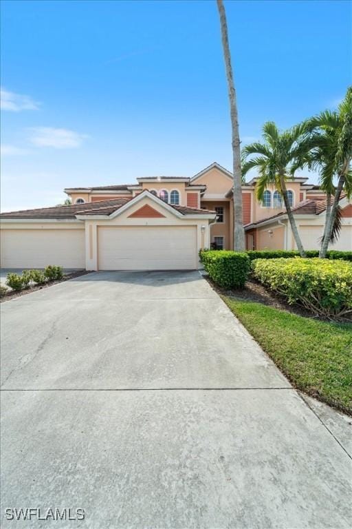 view of front of home featuring concrete driveway, an attached garage, and stucco siding