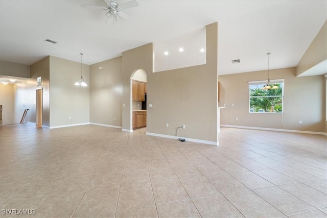 empty room with visible vents, light tile patterned flooring, baseboards, and ceiling fan with notable chandelier