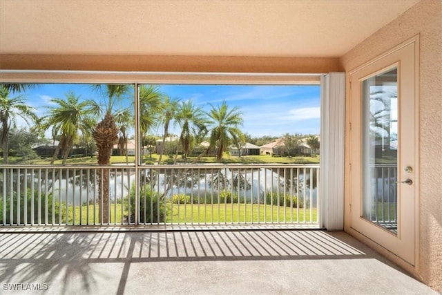 unfurnished sunroom featuring a water view