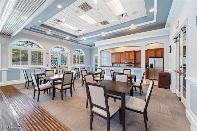 dining room with a tray ceiling and visible vents