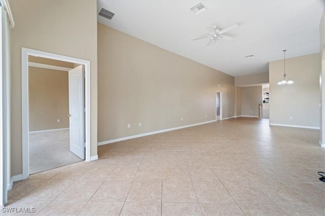 unfurnished room featuring light tile patterned flooring, visible vents, baseboards, and ceiling fan with notable chandelier