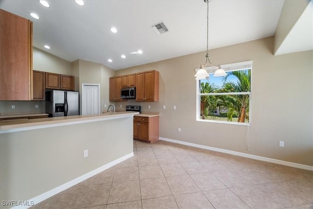 kitchen featuring stainless steel appliances, visible vents, hanging light fixtures, light countertops, and brown cabinets